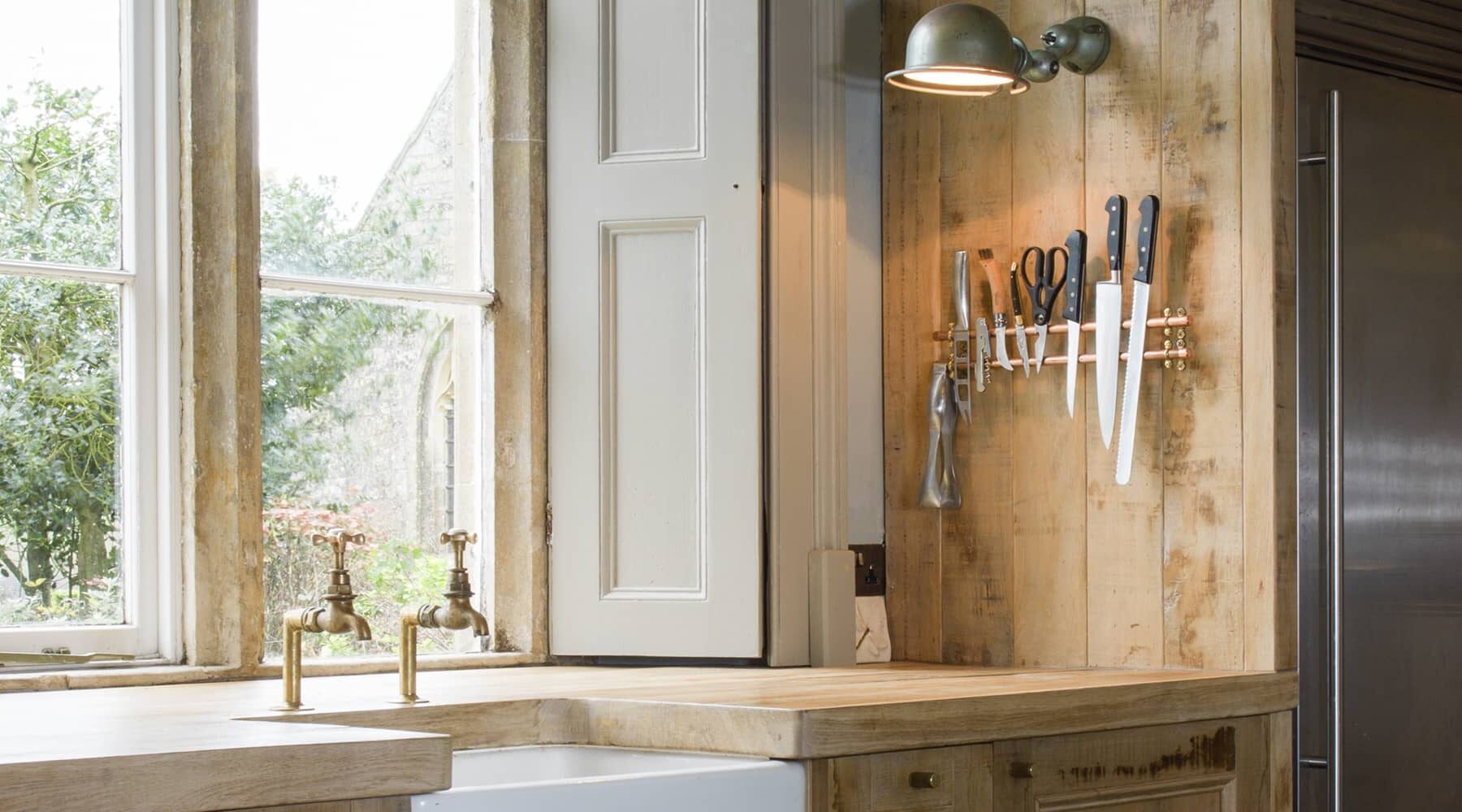 Rustic oak kitchen with large stainless steel fridge freezer and large sunken ceramic sink. designed by Mia Marquez