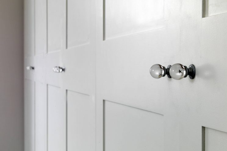 White wardrobe in bedroom with glass door knobs
