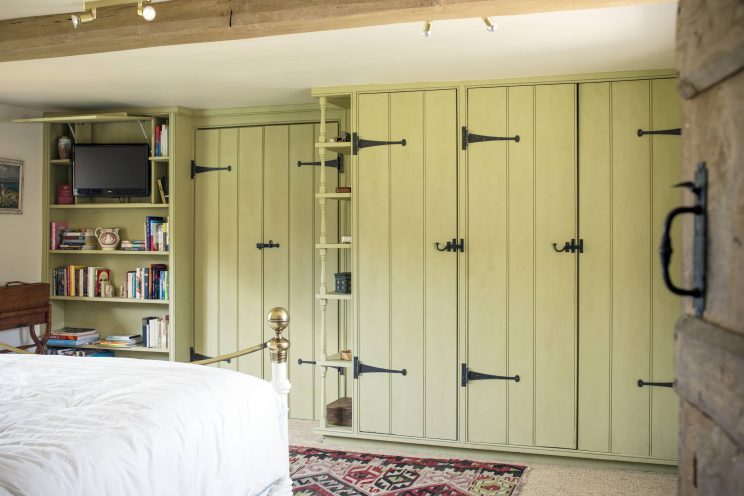 Country style wardrobe in bedroom with bespoke ironmongery