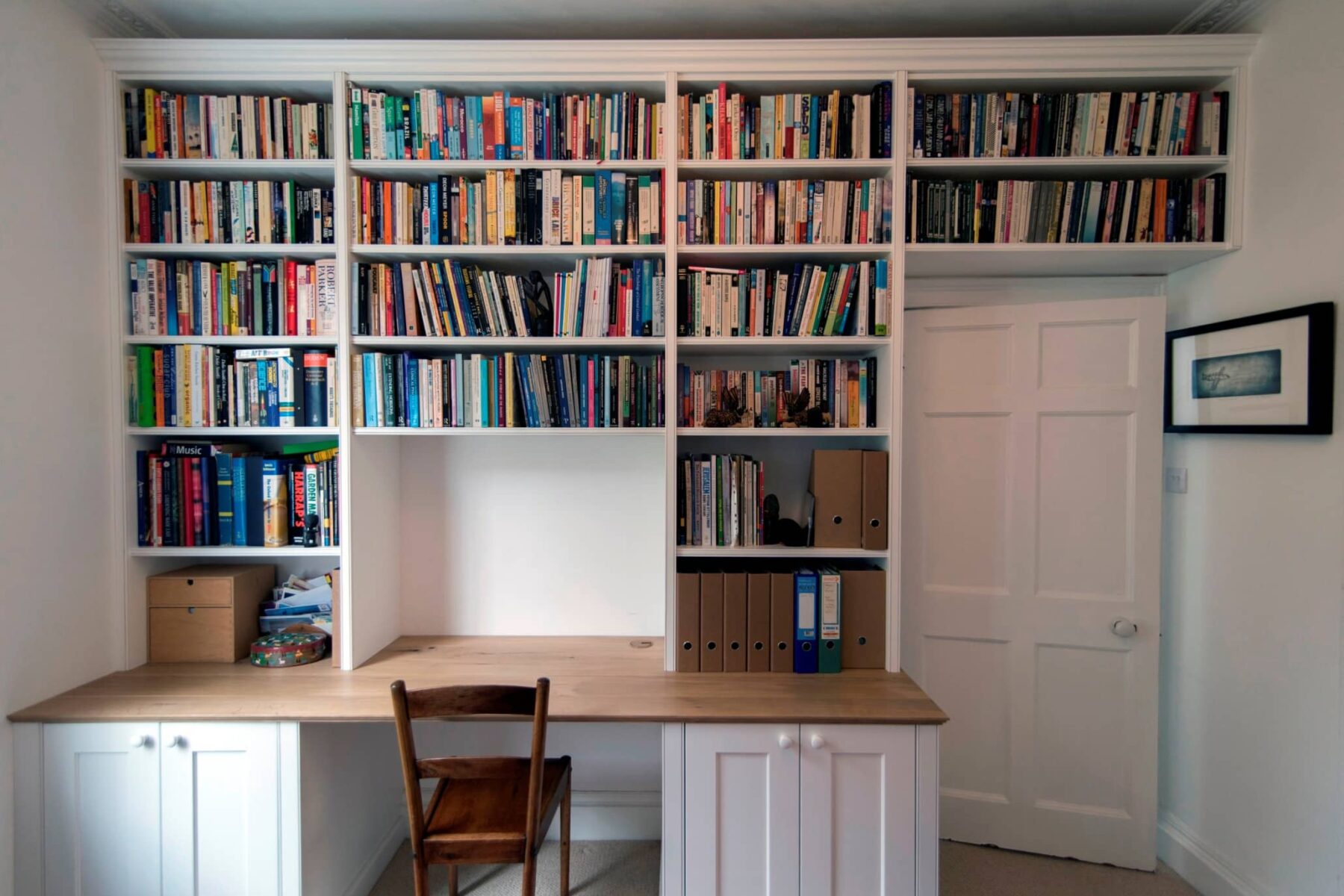 Study room with large wall length fitted bookcases