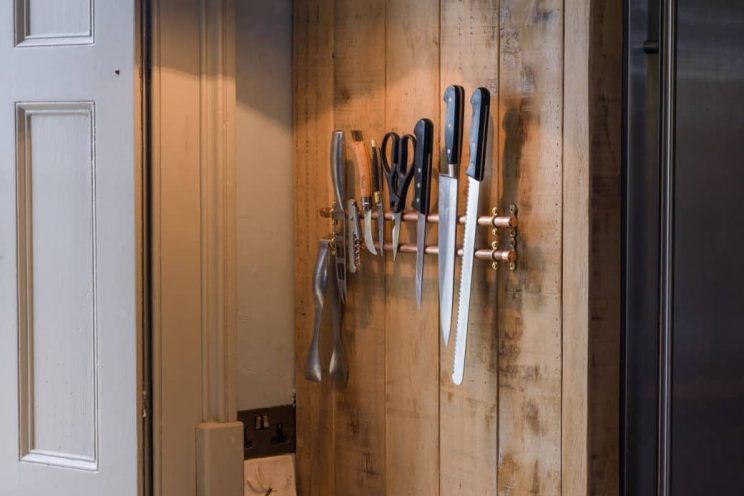 Rustic sustainable kitchen with magnetic knife storage designed by Mia Marquez