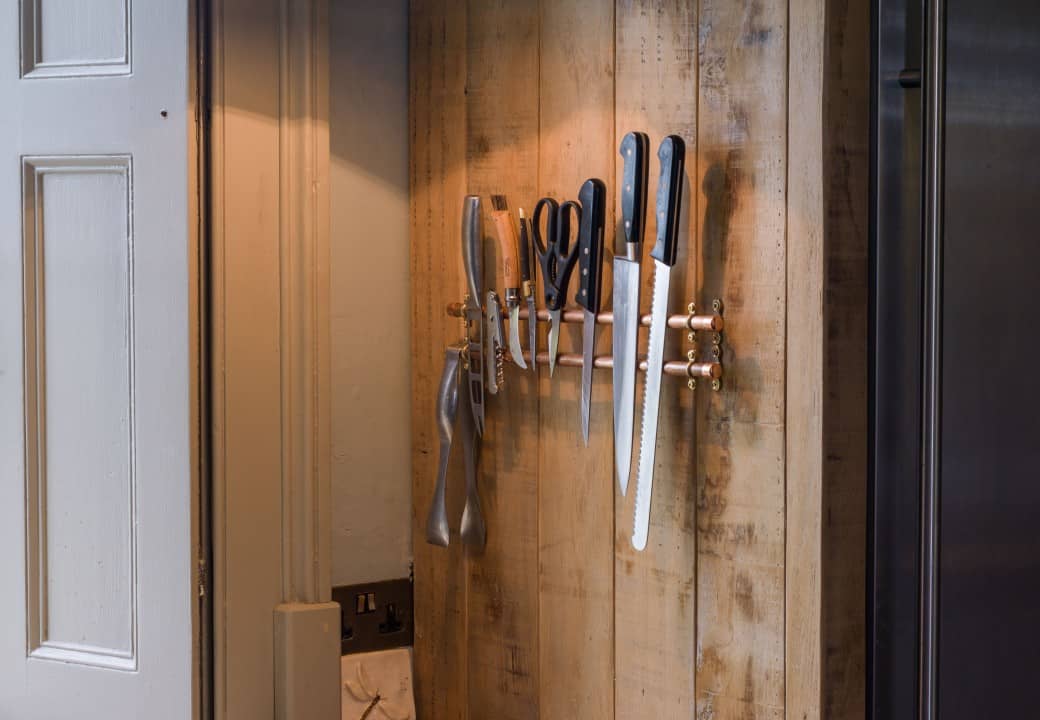 Rustic sustainable kitchen with magnetic knife storage designed by Mia Marquez