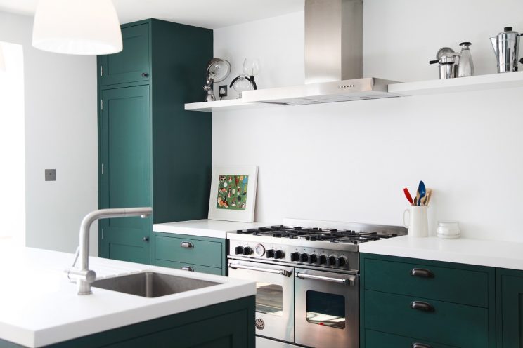 Green shaker kitchen with white Corian worktop