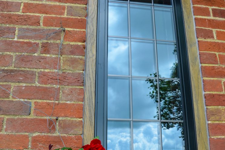 Black casement window in red brick home