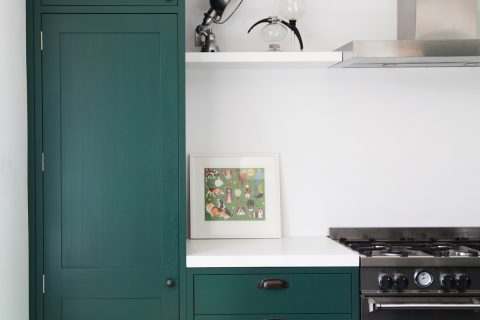 Green shaker kitchen with white Corian worktop