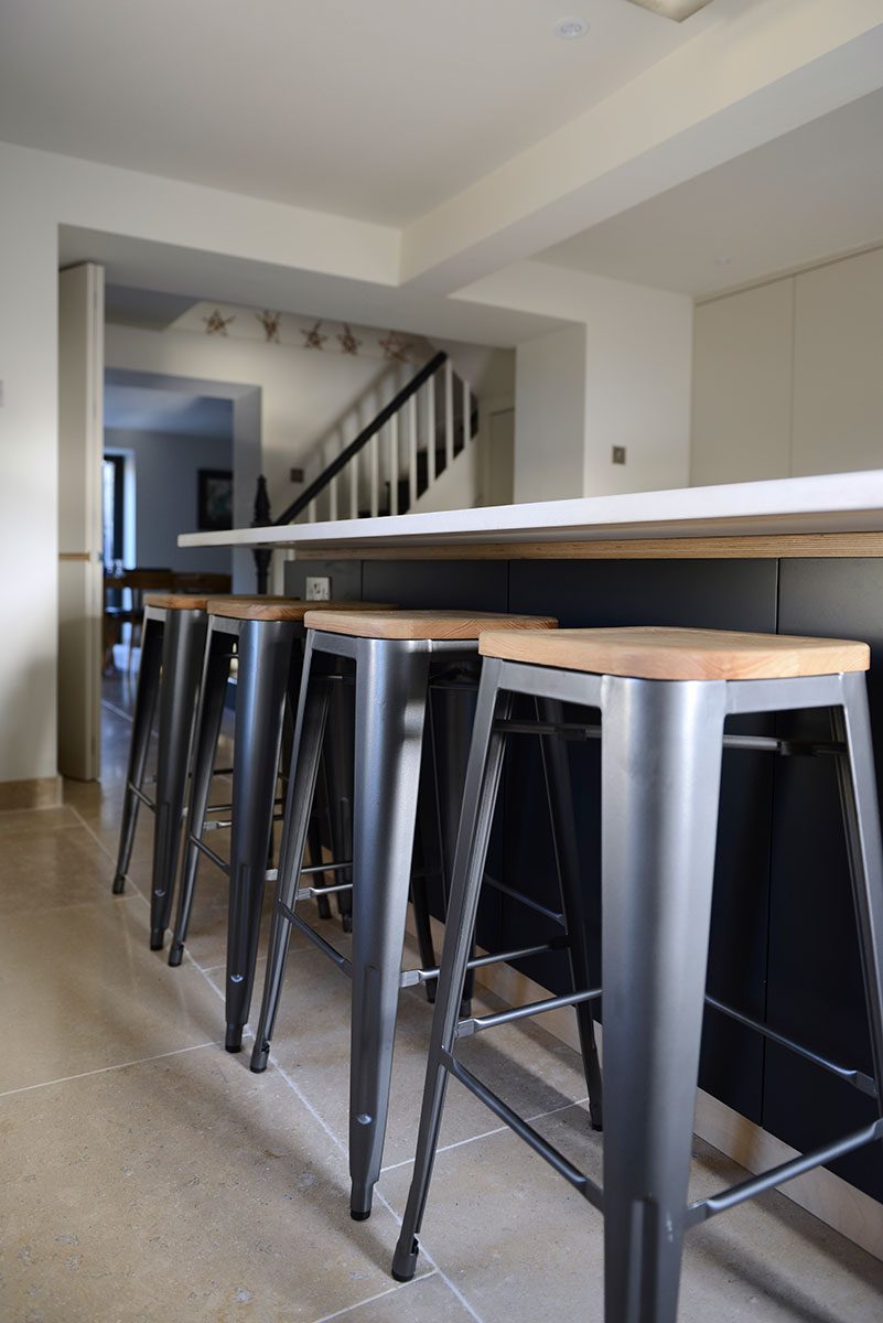 Modern kitchen island with Silestone counter top and metal stools
