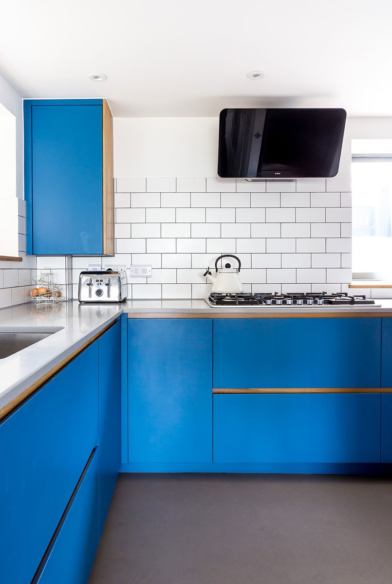 Electric blue kitchen with Corian worktop and white tiles