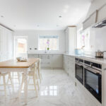 Contemporary white Shaker kitchen in Bath with large larders