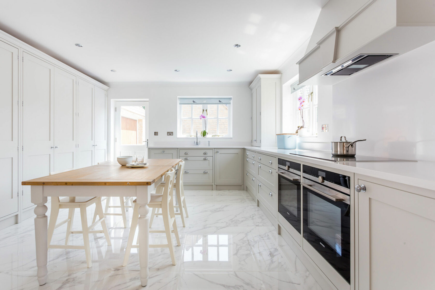 Contemporary white Shaker kitchen in Bath with large larders