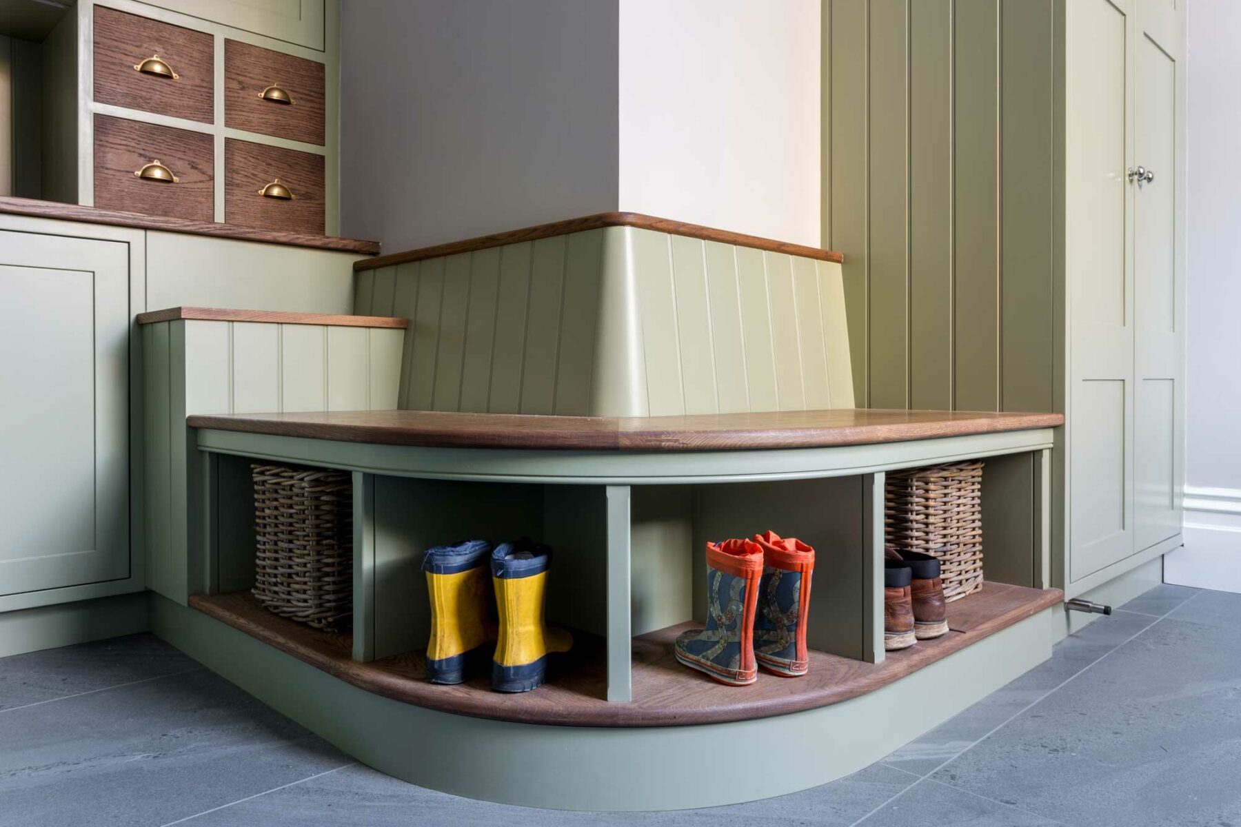 Curved seating area in boot room with wooden wall panelling