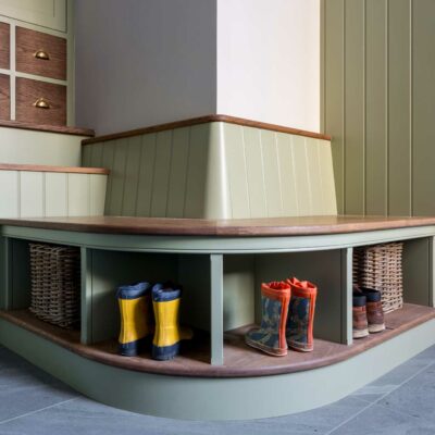 Curved seating area in boot room with wooden wall panelling