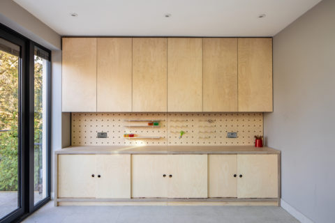 Built-in cupboards with pegboard shelves - kids craft station in birch ply