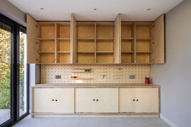 Built-in cupboards with pegboard shelves - kids craft station in birch ply
