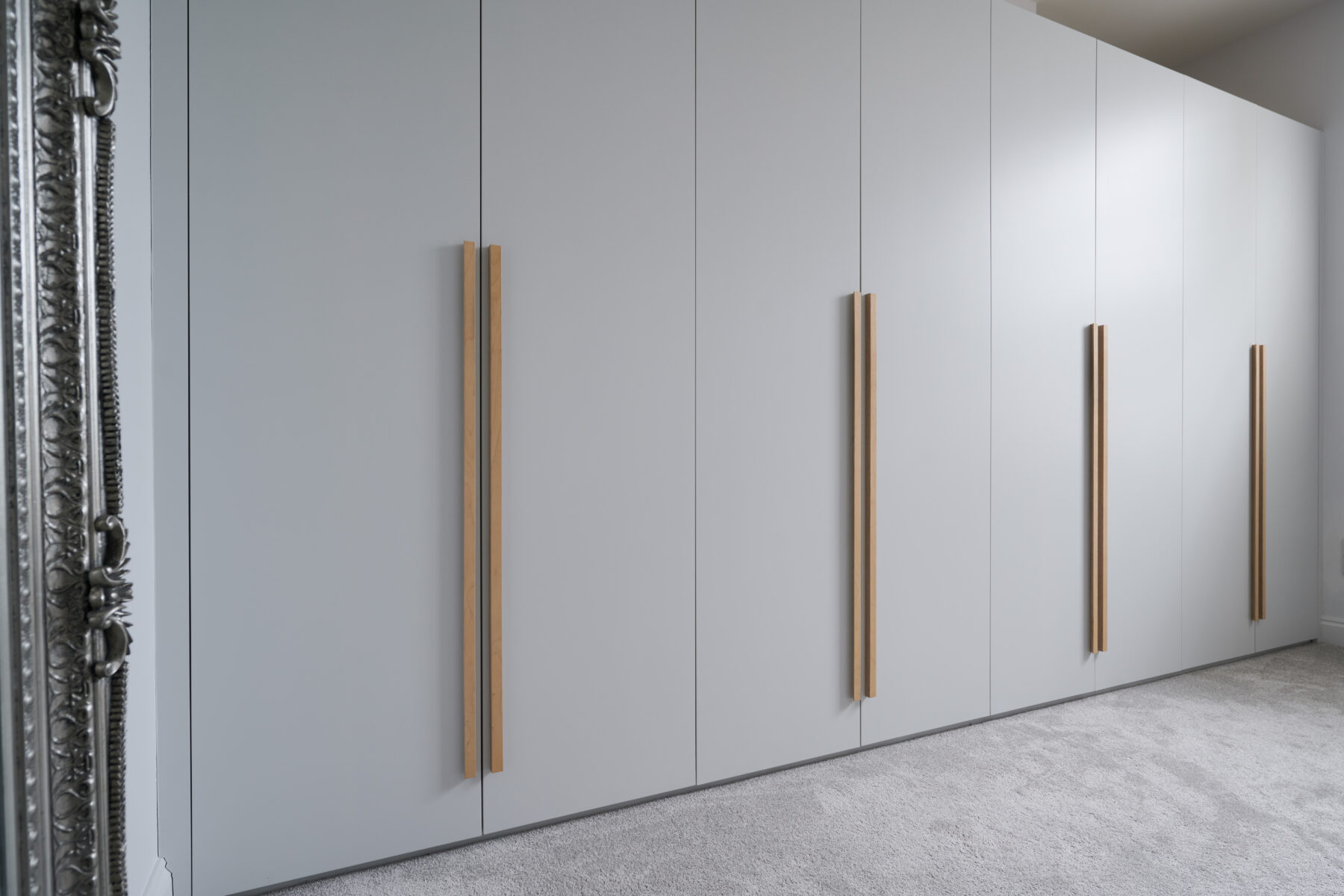 Contemporary slab door wardrobes with bespoke wooden handles
